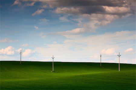 schienenkreuzung - Power-transmission poles on the empty field in spring Stockbilder - Microstock & Abonnement, Bildnummer: 400-05336009