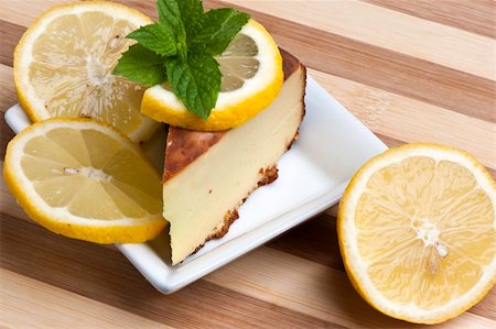 A piece of lemon cake decorated with lemon slices and mint leaves Photographie de stock - Aubaine LD & Abonnement, Code: 400-05331690