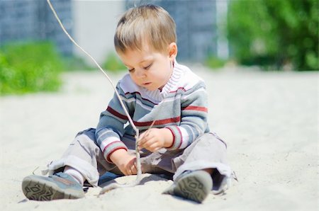 The cute boy plaing on a sand Foto de stock - Super Valor sin royalties y Suscripción, Código: 400-05333741