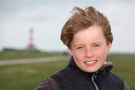 Young boy in front of a lighthouse blown over by the wind with tousled hair Stock Photo - Budget Royalty-Free & Subscription, Code: 400-05344221