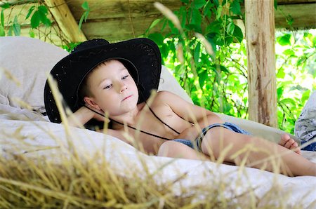 small babies in park - boy in a cowboy hat is in the hayloft Photographie de stock - Aubaine LD & Abonnement, Code: 400-05344683