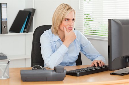 simsearch:400-04894274,k - Working thoughtful woman in front of a screen looking at it in an office Stock Photo - Budget Royalty-Free & Subscription, Code: 400-05345219