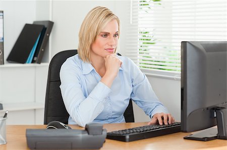 Working serious woman in front of a screen looking at it in an office Stock Photo - Budget Royalty-Free & Subscription, Code: 400-05345230