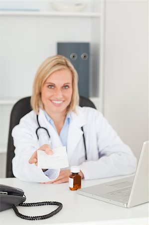 simsearch:400-04417775,k - Smiling doctor holding prescription looks into camera in her office Foto de stock - Super Valor sin royalties y Suscripción, Código: 400-05345314