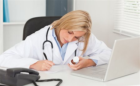 simsearch:400-04417775,k - Doctor writing something down holding medicine in her office Foto de stock - Super Valor sin royalties y Suscripción, Código: 400-05345313