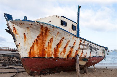 san cristobal island - An old boat, weathered by the elements, is pulled up on the beach in the harbor of Puerto Baquerizo Moreno on the Galapagos Islands. Stock Photo - Budget Royalty-Free & Subscription, Code: 400-05345455
