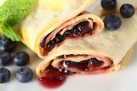 Rolled pancakes filled with blueberry jam surrounded by fresh blueberries (Selective Focus, Focus on the front of the jam filling of both halves) Stock Photo - Budget Royalty-Free & Subscription, Code: 400-05345507