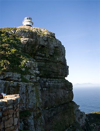 The old lighthouse at Cape Point, South Africa is a beacon that helps ships navigate around the Cape of Good Hope between the Indian and Atlantic Oceans. Foto de stock - Super Valor sin royalties y Suscripción, Código: 400-05345977