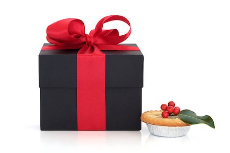 Black gift box with red satin ribbon and bow and christmas mince pie with holly berry leaf sprig isolated over white background. Stock Photo - Budget Royalty-Free & Subscription, Code: 400-05346718