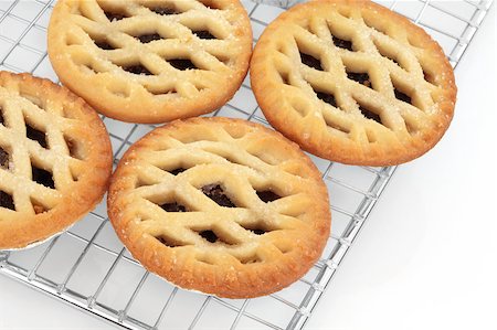 Christmas latticed mince pie group on a baking metal cooling rack over white background. Selective focus Stock Photo - Budget Royalty-Free & Subscription, Code: 400-05346720
