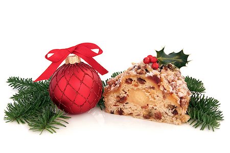 Stollen christmas cake with holly berry, red bauble decoration and blue pine fir sprigs isolated over white background. Stock Photo - Budget Royalty-Free & Subscription, Code: 400-05346736
