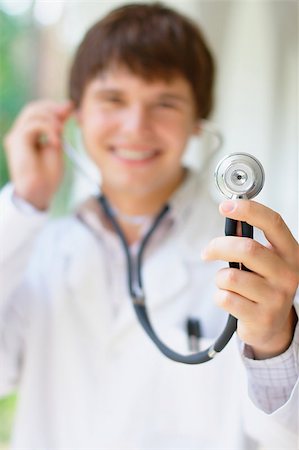 doctor and teenage boy - Close-up photo of young smiling doctor holding a stethoscope Stock Photo - Budget Royalty-Free & Subscription, Code: 400-05347193