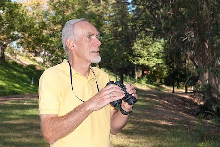 Healthy old man with binoculars engaged in his hobby of birdwatching in a wooded landscape. Photographie de stock - Aubaine LD & Abonnement, Code: 400-05340918