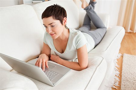 Charming dark-haired woman using a laptop in her living room Stock Photo - Budget Royalty-Free & Subscription, Code: 400-05343187
