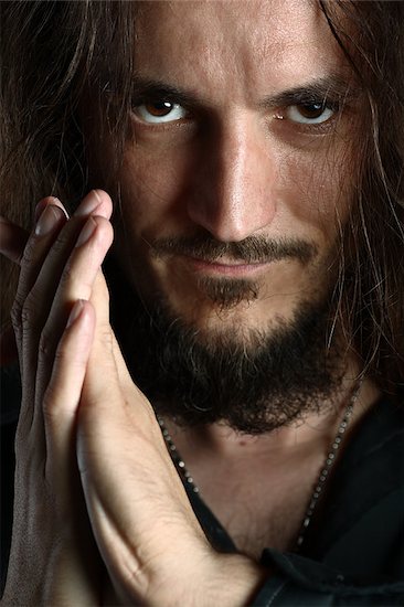 Young guy with long hair looks into camera while praying, face detail Foto de stock - Sin royalties, Artista: PeterPolak, Código de la imagen: 400-05343465