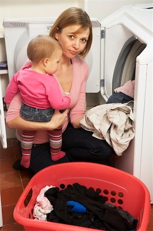 simsearch:693-06019442,k - Woman Doing Laundry And Holding Baby Daughter Photographie de stock - Aubaine LD & Abonnement, Code: 400-05354716
