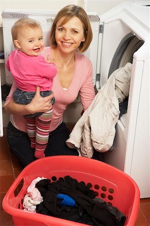 family with washing machine - Woman Doing Laundry And Holding Baby Daughter Photographie de stock - Aubaine LD & Abonnement, Code: 400-05354717