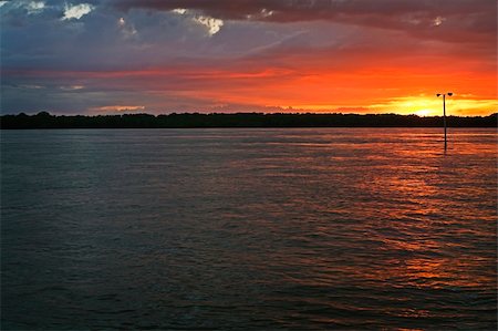 simsearch:400-07975760,k - A street lamp stands in flood water in an urban setting along the Mississippi River at sunset. Fotografie stock - Microstock e Abbonamento, Codice: 400-05355502