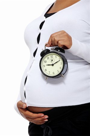 simsearch:400-04582878,k - Pregnant woman holding  alarm clock  , isolated on white background Foto de stock - Super Valor sin royalties y Suscripción, Código: 400-05356515