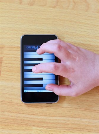 Playing piano on modern touch screen phone Stock Photo - Budget Royalty-Free & Subscription, Code: 400-05357005