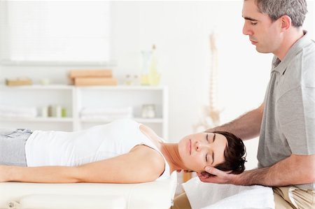 Chiropractor stretching a charming woman in a room Stockbilder - Microstock & Abonnement, Bildnummer: 400-05357087