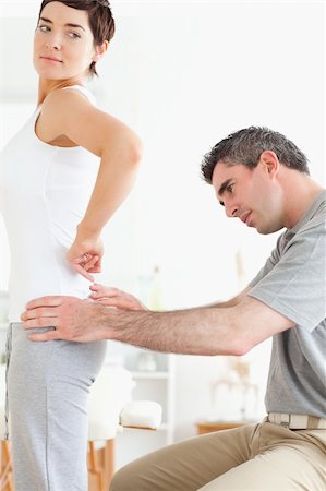 physical therapy shoulder - Chiropractor examining a brunette woman's back in a room Stock Photo - Budget Royalty-Free & Subscription, Code: 400-05357133