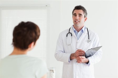 Doctor talking to a cute woman in a room Stock Photo - Budget Royalty-Free & Subscription, Code: 400-05357177