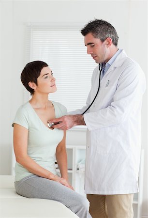 Doctor examining a brunette woman in a room Stock Photo - Budget Royalty-Free & Subscription, Code: 400-05357172