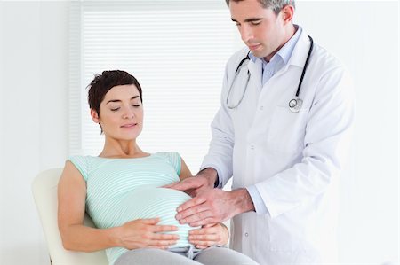 Doctor ausculating a pregnant woman's tummy in a room Stock Photo - Budget Royalty-Free & Subscription, Code: 400-05357224