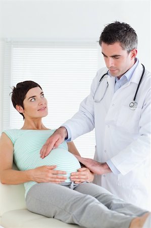 Doctor examining a pregnant woman's tummy in a room Stock Photo - Budget Royalty-Free & Subscription, Code: 400-05357221