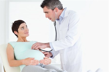 Doctor examining the woman's tummy with a stethoscope in a room Stock Photo - Budget Royalty-Free & Subscription, Code: 400-05357234