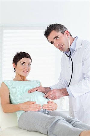 Doctor examining a pregnant woman with a stethoscope in a room Stock Photo - Budget Royalty-Free & Subscription, Code: 400-05357237