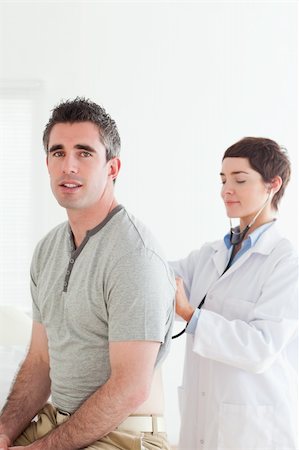 Doctor examining a patient with a stethoscope in a room Stock Photo - Budget Royalty-Free & Subscription, Code: 400-05357246