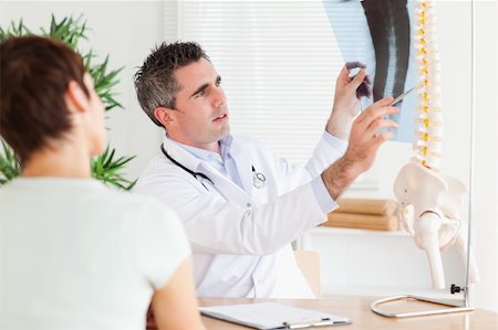 patient talking to office worker - Male Doctor showing a patient a x-ray in a room Stock Photo - Budget Royalty-Free & Subscription, Code: 400-05357296