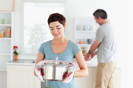 simsearch:400-05357733,k - Cute Woman holding a pot while man is washing the dishes in a kitchen Fotografie stock - Microstock e Abbonamento, Codice: 400-05357335