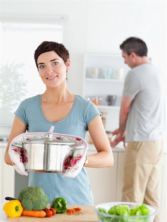 simsearch:400-05357733,k - Charming wife holding a pot while her husband is washing the dishes in a kitchen Fotografie stock - Microstock e Abbonamento, Codice: 400-05357338