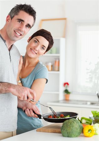 family eating dinner kitchen - Gorgeous Woman and her pan-holding husband looking into the camera in a kitchen Stock Photo - Budget Royalty-Free & Subscription, Code: 400-05357359
