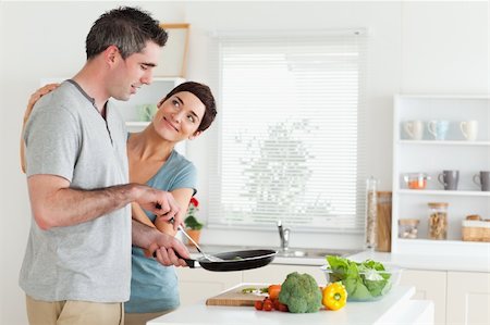 family eating dinner kitchen - Woman smiling at her husband in a kitchen Stock Photo - Budget Royalty-Free & Subscription, Code: 400-05357351