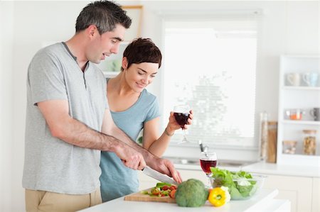 family eating dinner kitchen - Man cutting vegetables while is woman is watching in a kitchen Stock Photo - Budget Royalty-Free & Subscription, Code: 400-05357361