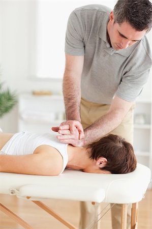 A masseur is massaging a female customer's neck in his surgery Stockbilder - Microstock & Abonnement, Bildnummer: 400-05357435
