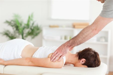 A masseur is massaging a woman's back in his surgery Stockbilder - Microstock & Abonnement, Bildnummer: 400-05357440