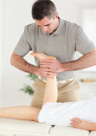 A woman's leg is massaged by a masseur in his surgery Stockbilder - Microstock & Abonnement, Bildnummer: 400-05357453