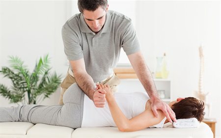 A masseur is stretching a woman's arm Stockbilder - Microstock & Abonnement, Bildnummer: 400-05357485