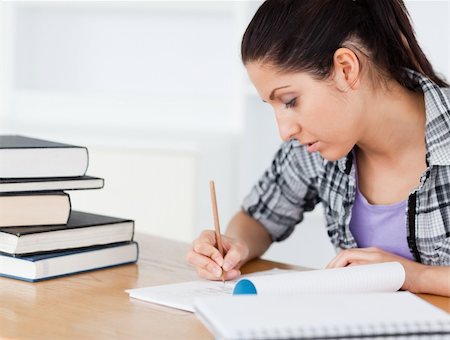 simsearch:400-04175049,k - A young student is doing her homework between books Stock Photo - Budget Royalty-Free & Subscription, Code: 400-05357548