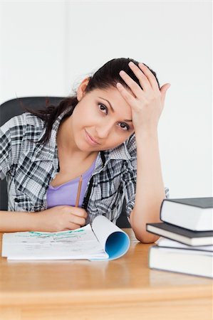 simsearch:400-04175049,k - A smiling student sitting in front of her homework Stock Photo - Budget Royalty-Free & Subscription, Code: 400-05357564