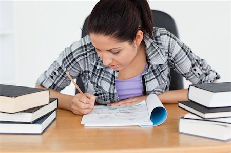 simsearch:400-04175049,k - A young student is writing into her exercise book Stock Photo - Budget Royalty-Free & Subscription, Code: 400-05357571