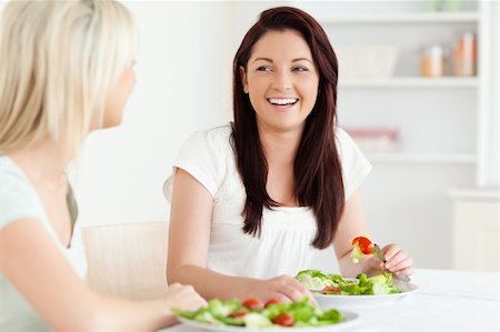 simsearch:400-05357733,k - Portrait of laughing Women eating salad in a kitchen Fotografie stock - Microstock e Abbonamento, Codice: 400-05357654