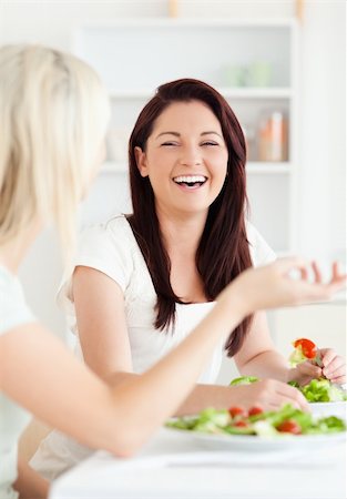 simsearch:400-05357733,k - Portrait of cheerful Women eating salad in a kitchen Fotografie stock - Microstock e Abbonamento, Codice: 400-05357657