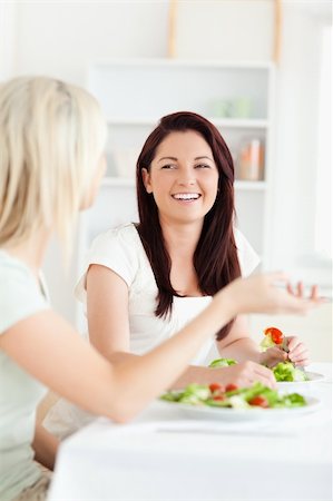 simsearch:400-05357733,k - Portrait of gorgeous Women eating salad in a kitchen Fotografie stock - Microstock e Abbonamento, Codice: 400-05357658