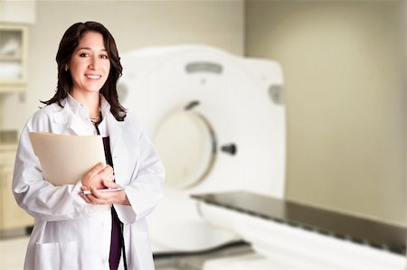 doctor with ct scan - Beautiful happy female doctor physician radiologist holding patient medical chart and pen standing in CT CAT Scan room at hospital, isolated. Stock Photo - Budget Royalty-Free & Subscription, Code: 400-05357676